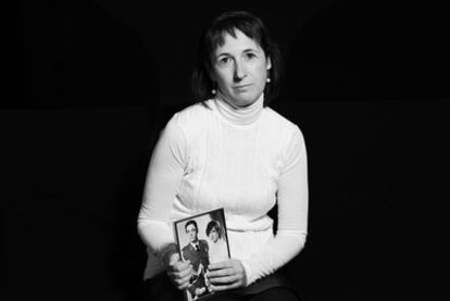 Lourdes Rodao, the widow of soldier Luis Conde, holds up her wedding photo. Conde was killed in her presence in 2008.