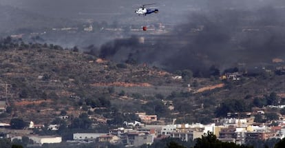 Un helic&oacute;ptero sobrevuela el fuego en Pedralba.