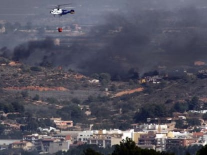 Un helic&oacute;ptero sobrevuela el fuego en Pedralba.