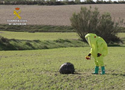 Un agente de los Tedax inspecciona el artefacto caído este martes en un campo de Mula (Murcia). La Guardia Civil activó de inmediato el protocolo NRBQ (nuclear, radiológico, bacteriológico y químico).