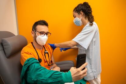 Una enfermera vacuna contra la covid-19 a un sanitario en el hospital Gregorio Marañón de Madrid, el domingo.