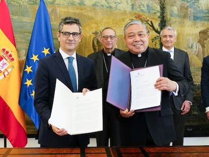 El ministro de la Presidencia, Félix Bolaños (a la izquierda), intercambia documentos con el nuncio en España, el arzobispo Bernardito Auza, durante un encuentro celebrado este miércoles en Madrid. Al fondo, en el centro, Juan José Omella, presidente de la Conferencia Episcopal.