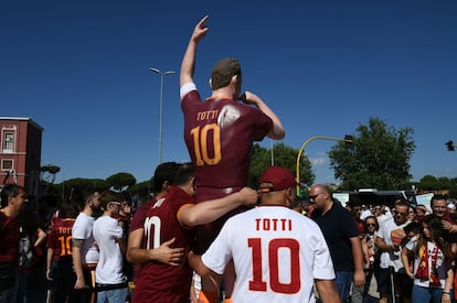 Aficionados de la Roma posan con una estatua de Totti en la ciudad. 