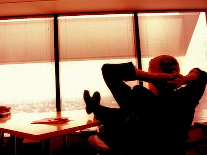 Un hombre se relaja en su despacho disfrutando de las vistas.