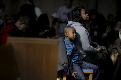 Un niño espera junto a su madre la llegada del candidato demócrata a la presidencia de los Estados Unidos, Bernie Sanders, durante un acto electoral en Flint, en el estado de Michigan, el 25 de febrero de 2016.