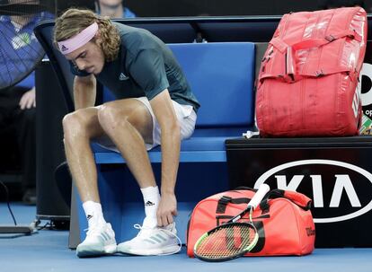 Stefanos Tsitsipas se cambia de zapatillas durante un descanso.