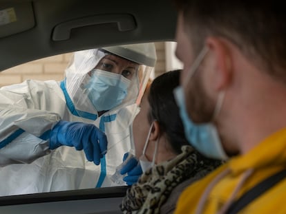 Personal sanitario toma muestras a usuarios, en su propio vehículo, para una PCR en el hospital militar de Sevilla.