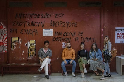 De izquierda a derecha: los estudiantes Stefanos, Alexandros, Eva, Mariana y Katerina, el jueves 18 de mayo en la facultad de Economía y Sociología de Atenas. La pintada de la pared dice: “Tus representantes matan a personas en las fronteras, pero a ti lo que te molesta son los grafitis”.