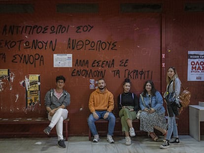 De izquierda a derecha: los estudiantes Stefanos, Alexandros, Eva, Mariana y Katerina, el jueves 18 de mayo en la facultad de Economía y Sociología de Atenas. La pintada de la pared dice: “Tus representantes matan a personas en las fronteras, pero a ti lo que te molesta son los grafitis”.