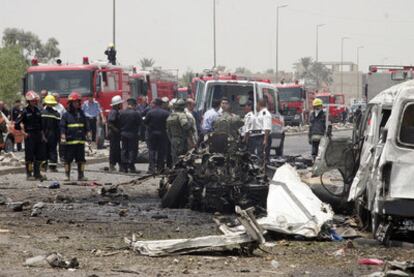 Bomberos y sanitarios cubren cadáveres en la zona de Bagdad donde han explotado dos coches bomba causando decenas de muertos
