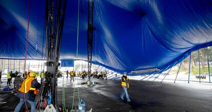 Un grupo de trabajadores levanta los postes.