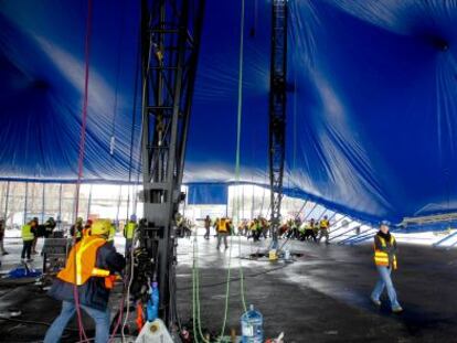Un grupo de trabajadores levanta los postes.