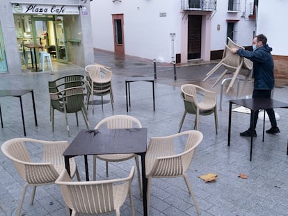 Un camarero recoge una terraza a las seis de la tarde, en Sevilla.