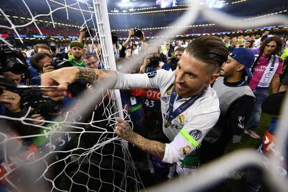 El capitán del Real Madrid, Sergio Ramos, corta un troza de la red de la portería del estadio de Cardiff.