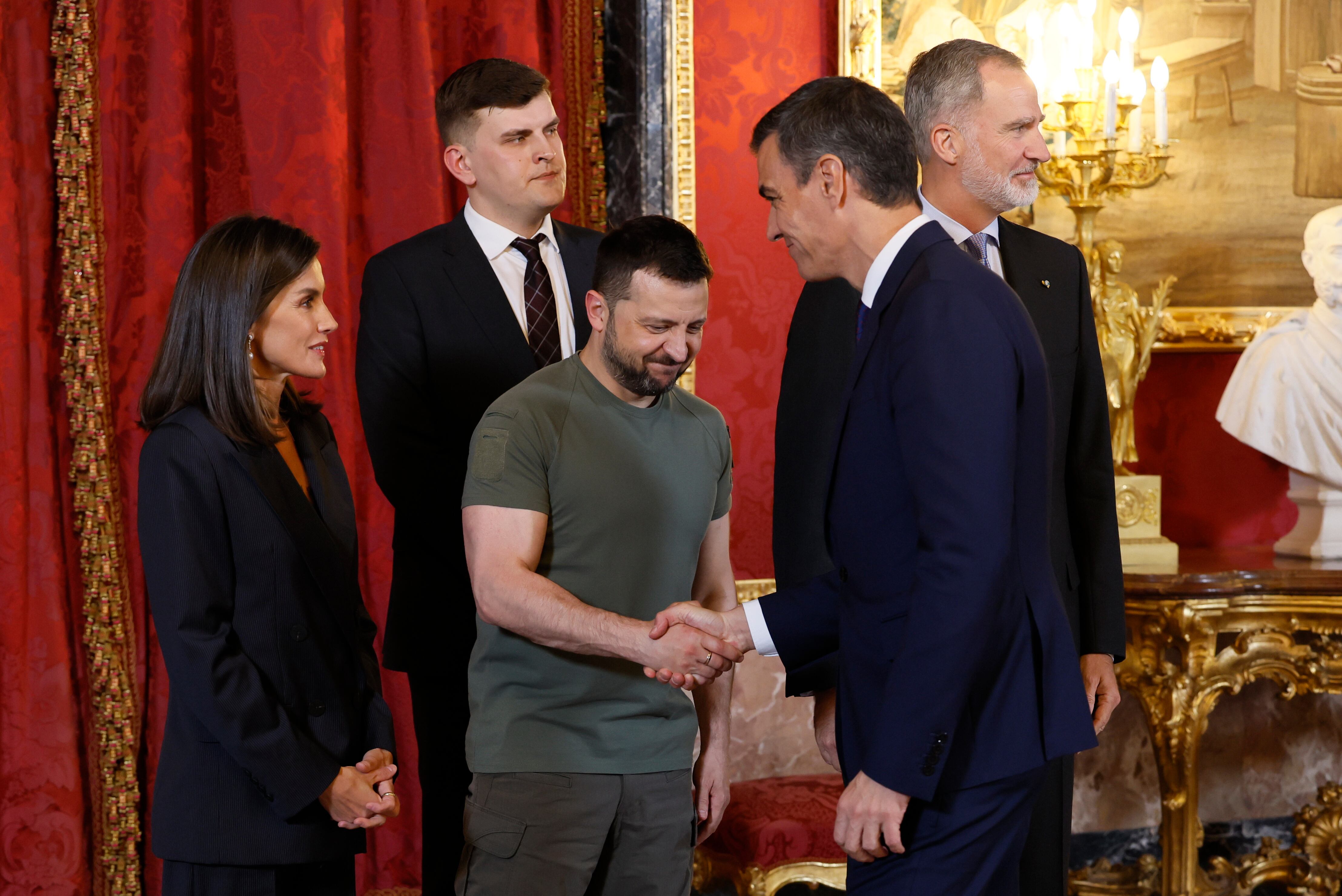 Los reyes de España Felipe VI y Letizia, junto al presidente de Ucrania, Volodímir Zelenski, saludan al presidente del Gobierno, Pedro Sánchez, durante el almuerzo ofrecido en el Palacio Real, este lunes en Madrid. 