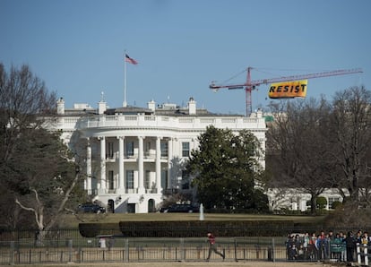 Ativistas do Greenpeace escalam um guindaste de construção de 80 metros de altura perto da Casa Branca e exibem uma grande faixa para chamar a resistência ao presidente Donald Trump por sua “negação da mudança climática, seu racismo, misoginia, homofobia e intolerância”, em 25 de janeiro de 2017.