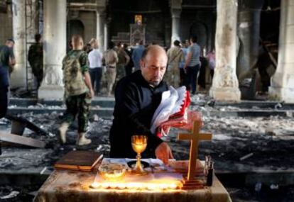 Un cristiano iraquí prepara la primera misa dominical en Qaraqosh desde que el ISIS fue expulsado de la localidad.