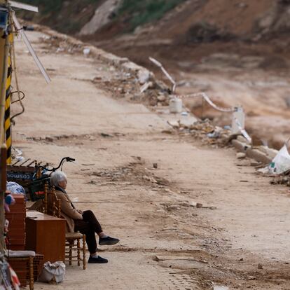 PICANYA (VALENCIA), 26/12/2024.- Una mujer descansa en una silla frente al barranco del Poyo en la localidad de Pincanya, Valencia, este jueves. EFE/ Kai Forsterling