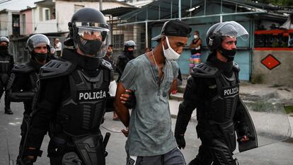 Dos policías llevan detenido a un hombre durante las protestas contra el Gobierno cubano en La Habana, este lunes.