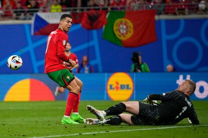 El checo Jindrich Stanek detiene un balón a Cristiano Ronaldo.