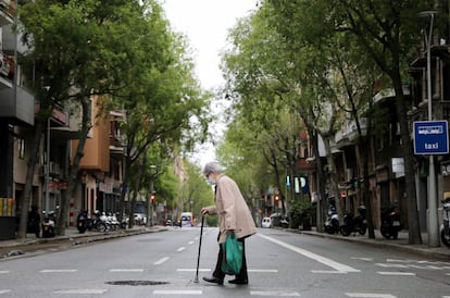 Una anciana protegida con una mascarilla camina por una calle de Barcelona, este miércoles. España supera los 100.000 contagiados y registra más de 800 muertos por quinto día consecutivo.