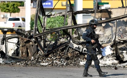 Um policial em frente a um veículo queimado nesta sexta-feira em Culiacán.