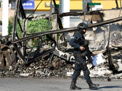 Um policial em frente a um veículo queimado nesta sexta-feira em Culiacán.