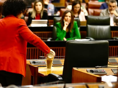 La diputada Maribel Mora derrama arena en el escaño del presidente de la Junta, Juan Manuel Moreno, en el pleno del Parlamento el 12 de abril.