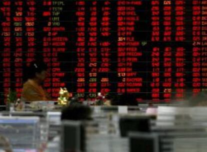 Un inversionista tailandés mira una pared de cifras que muestra los datos del mercado de ganado en la Bolsa de Tailanda en Bangkok.