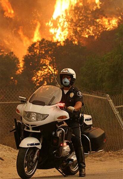 Un polica circula cerca del incendio, al noroeste de Los ?ngeles.