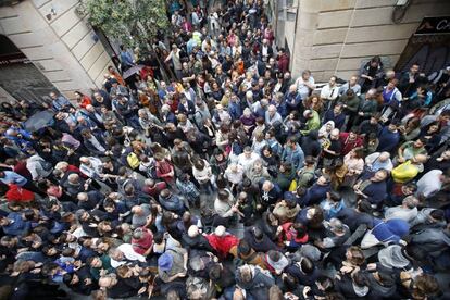 Pessoas esperam nos arredores do colégio Cervantes de Barcelona para votar.