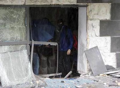 Dos agentes de la policía científica de la Ertzaintza observan los destrozos en la empresa Amenabar.