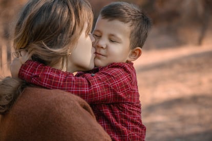 Una madre abraza a su hijo.