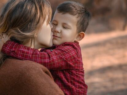 Una madre abraza a su hijo.