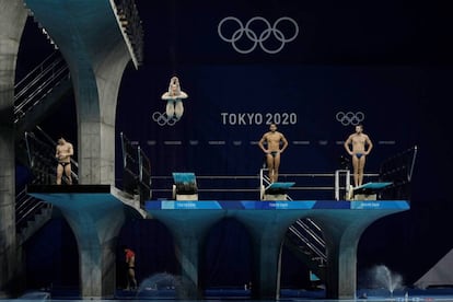 Varios deportistas durante su entrenamiento en salto de trampolín en el Centro Acuático de Tokio.