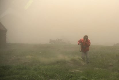 Un hombre camina sobre un campo de Vik, cerca del volcán. Los expertos han apuntado que este miércoles la actividad del volcán se ha ralentizado considerablemente y que mucha menos cantidad de ceniza está llegando a la atmósfera.