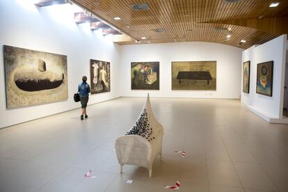 Una mujer pasea este viernes por la exposición 'Rotaciones', de Francisco Peinado en el centro cultural El Portón de Alhaurin de la Torre (Málaga). A la izquierda 'El submarino', en el centro 'La cuna' y, al fondo a la derecha, 'La mesa'.