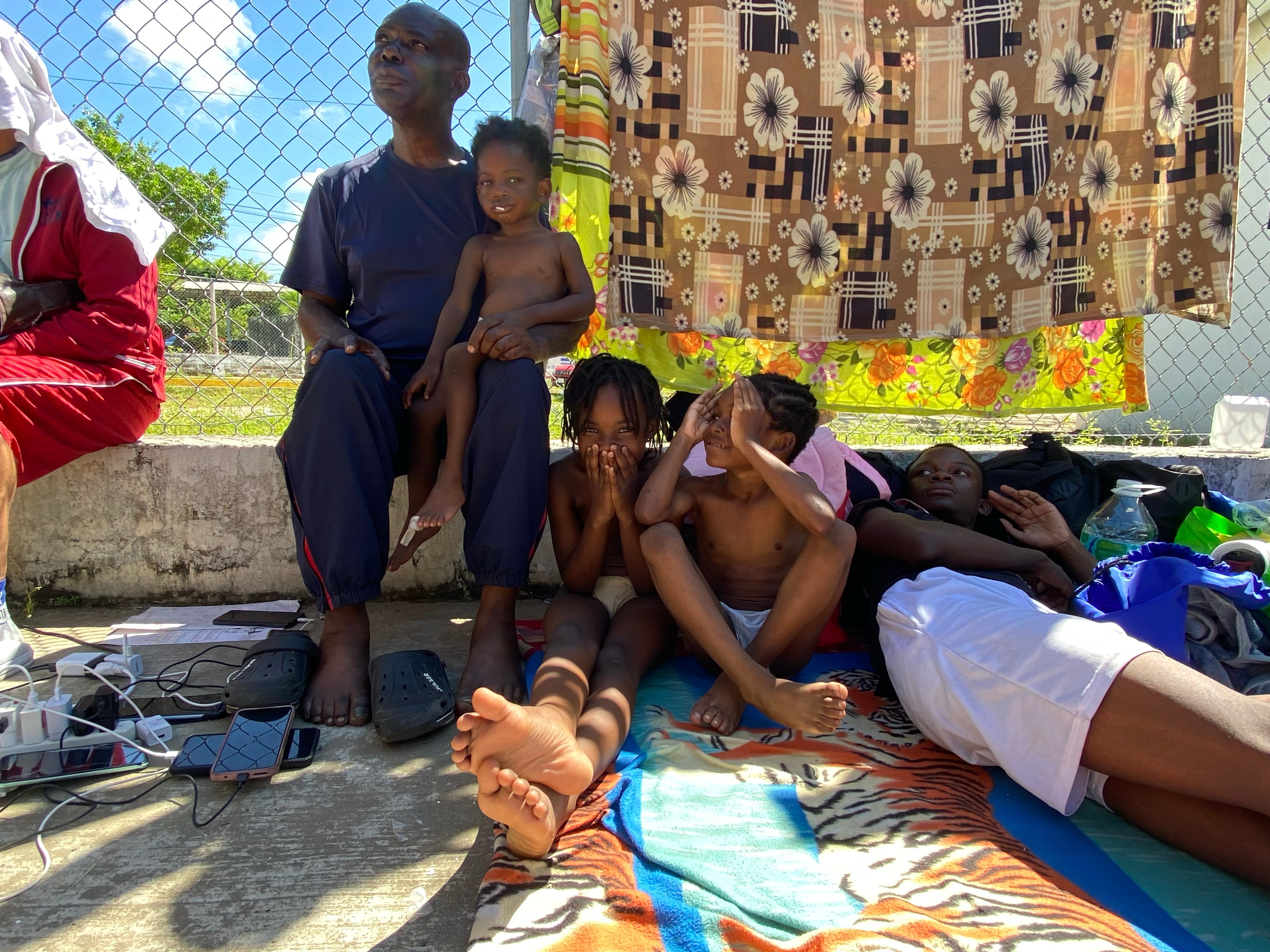 La familia de Efraím descansa en una cancha luego de caminar nueve horas en caravana con la intención de llegar a Estados Unidos.