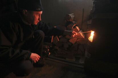 Un tártaro de Crimea alimenta un horno dentro de su vivienda en el asentamiento de Stroganovka en el distrito de Simferopol, Crimea.