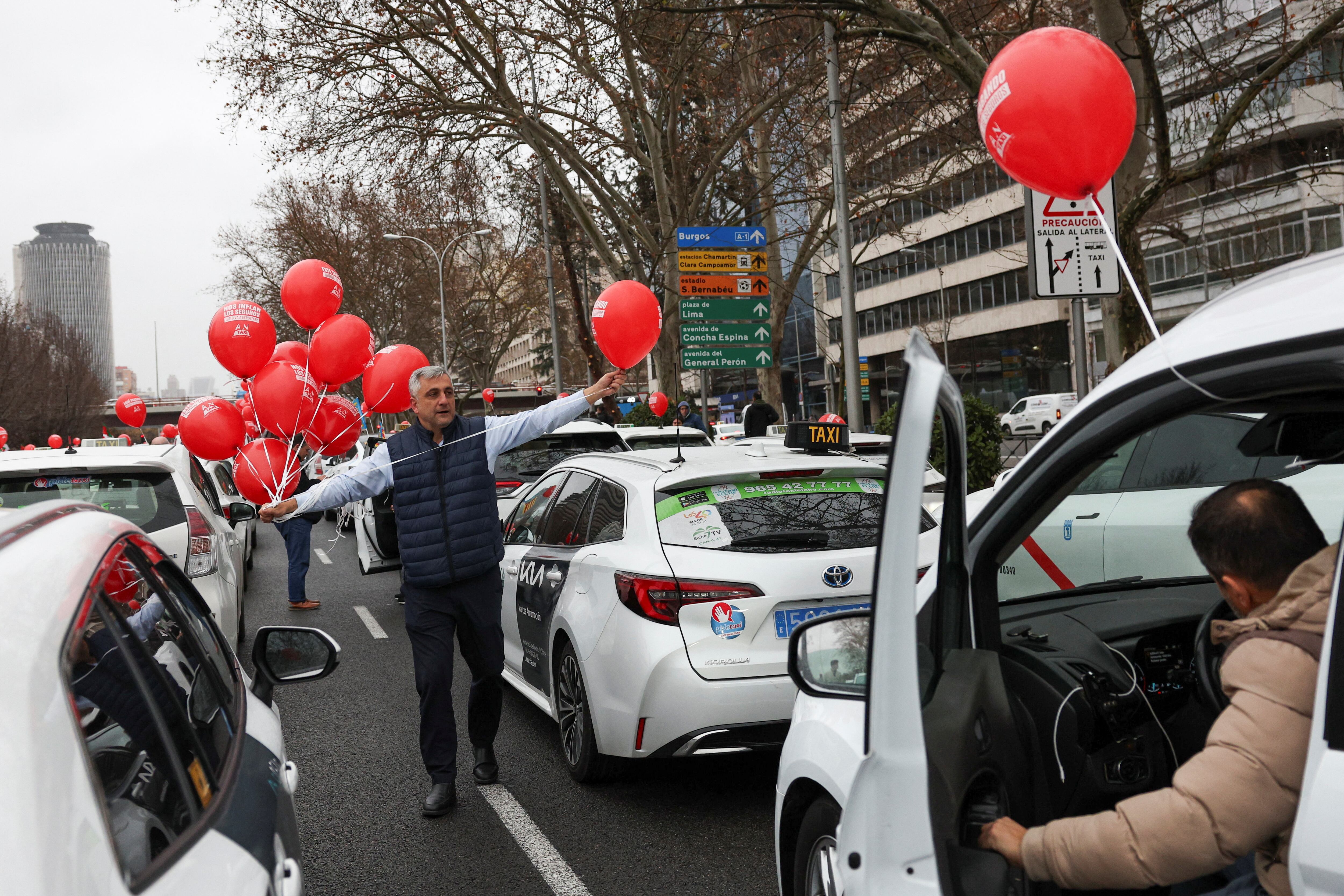 Un taxista entrega globos a otros conductores mientras se manifiesta durante una protesta nacional contra los altos costos de los seguros, en Madrid, España, el 29 de enero de 2025.