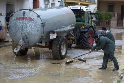 Labores de limpieza en las calles y casas de Cártama (Málaga), tras las fuertes lluvias.