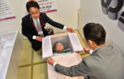 Una mujer prueba un ataúd en la feria del funeral en Tokio.