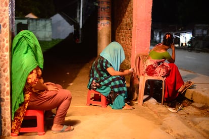 Tres trabajadoras sexuales esperan clientes junto al burdel de Kandapara. 