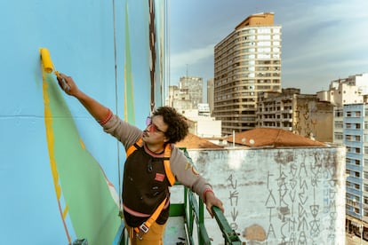 Tutano Nomade trabalha em um guindaste pintando um paredão no  centro histórico de São Paulo, dentro de um projeto municipal. 