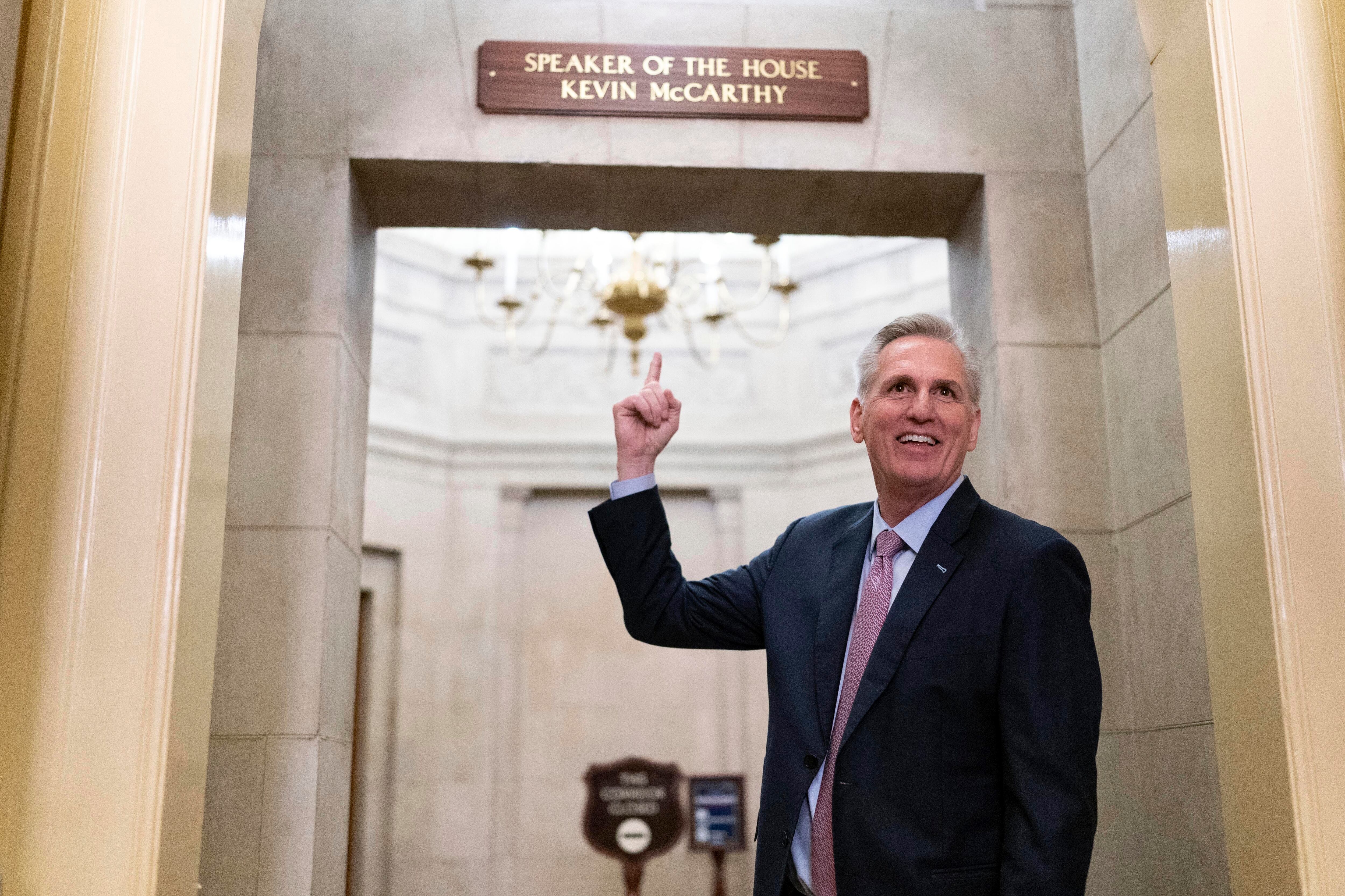 McCarthy señala el cartel de su despacho tras prestar juramento.