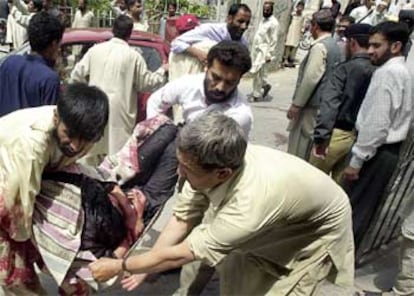 En la imagen, tres hombres trasladan a un herido durante el atentado.
