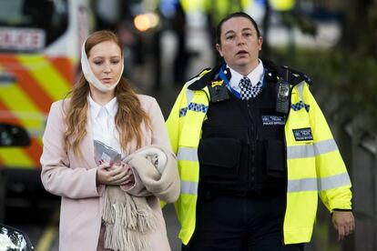 Una agente de policía escolta a una herida en los alrededores de la estación de metro Parsons Green en Londres (Reino Unido).