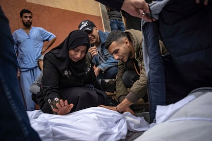 Un grupo de palestinos lloran a su familiar muerto en un bombardeo israelí sobre la franja de Gaza, en el hospital de Jan Yunis, antes de su funeral.