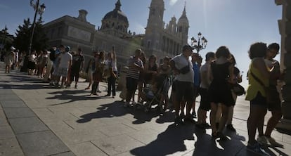 Turistas esperan delante de la Catedral de La Almudena para entrar en el Palacio Real.