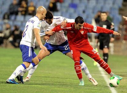 Reyes protege el balón ante Movilla y Álamo